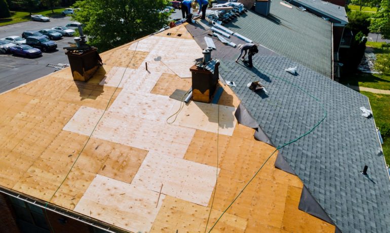 Roof repairs old roof replacement with new shingles of an apartment building